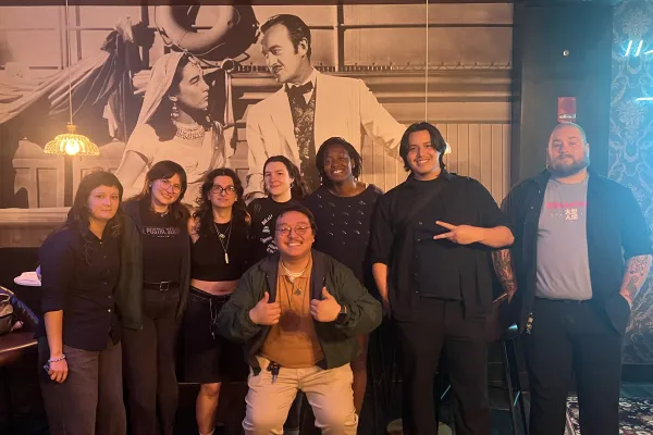 Group of eight workers for the Gateway Film Center, AFSCME Local 281, posing and smiling in a group photo after ratifying their contract