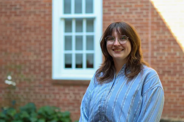 Photo of white woman with shoulder length brunette hair wearing a blue button down shirt