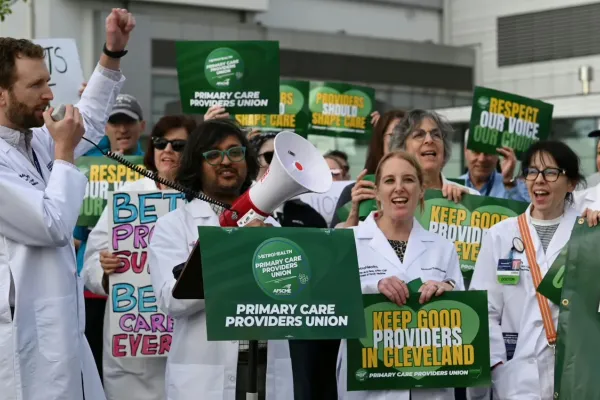 Photo of Metro Health Primary Care Providers rallying for their union in lab coats with signs