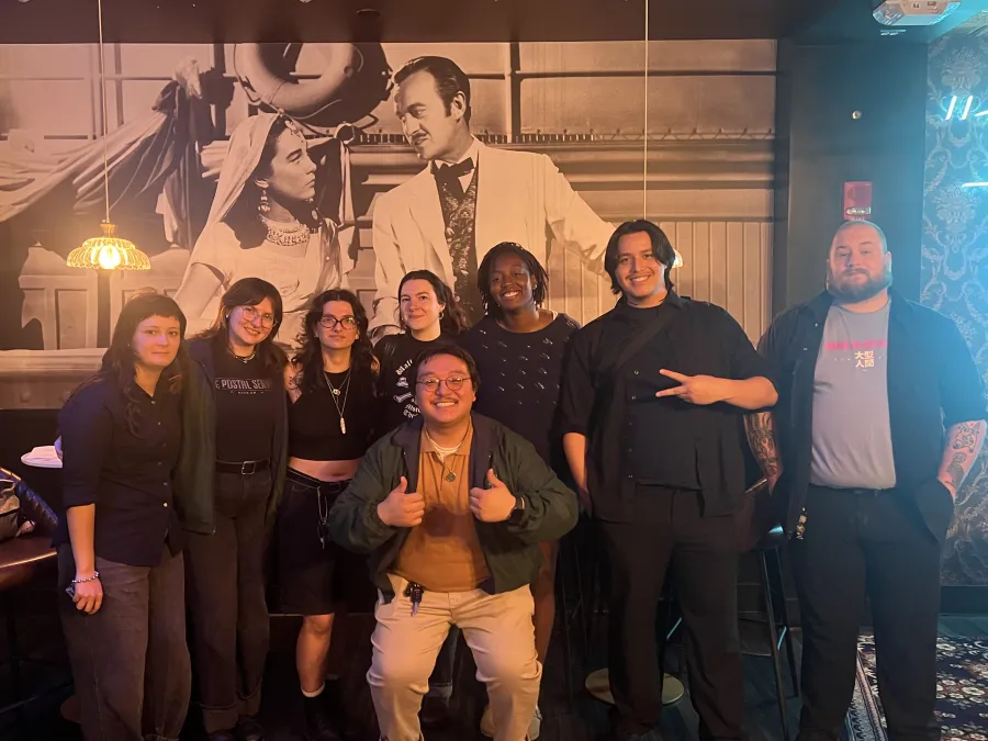 Group of eight workers for the Gateway Film Center, AFSCME Local 281, posing and smiling in a group photo after ratifying their contract