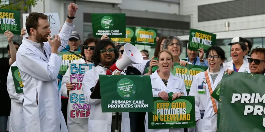 Photo of Metro Health Primary Care Providers rallying for their union in lab coats with signs