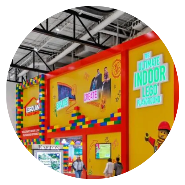 Photo of LEGOLAND Discovery Center Columbus, a large indoor mall setting with a large yellow and red Lego themsed exterior and many LEGO blocks and characters on the walls of the building