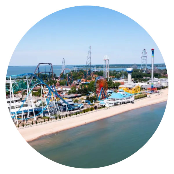 Photo of Cedar Point skyline, with rollercoasters and other theme park attractions along a beachfront